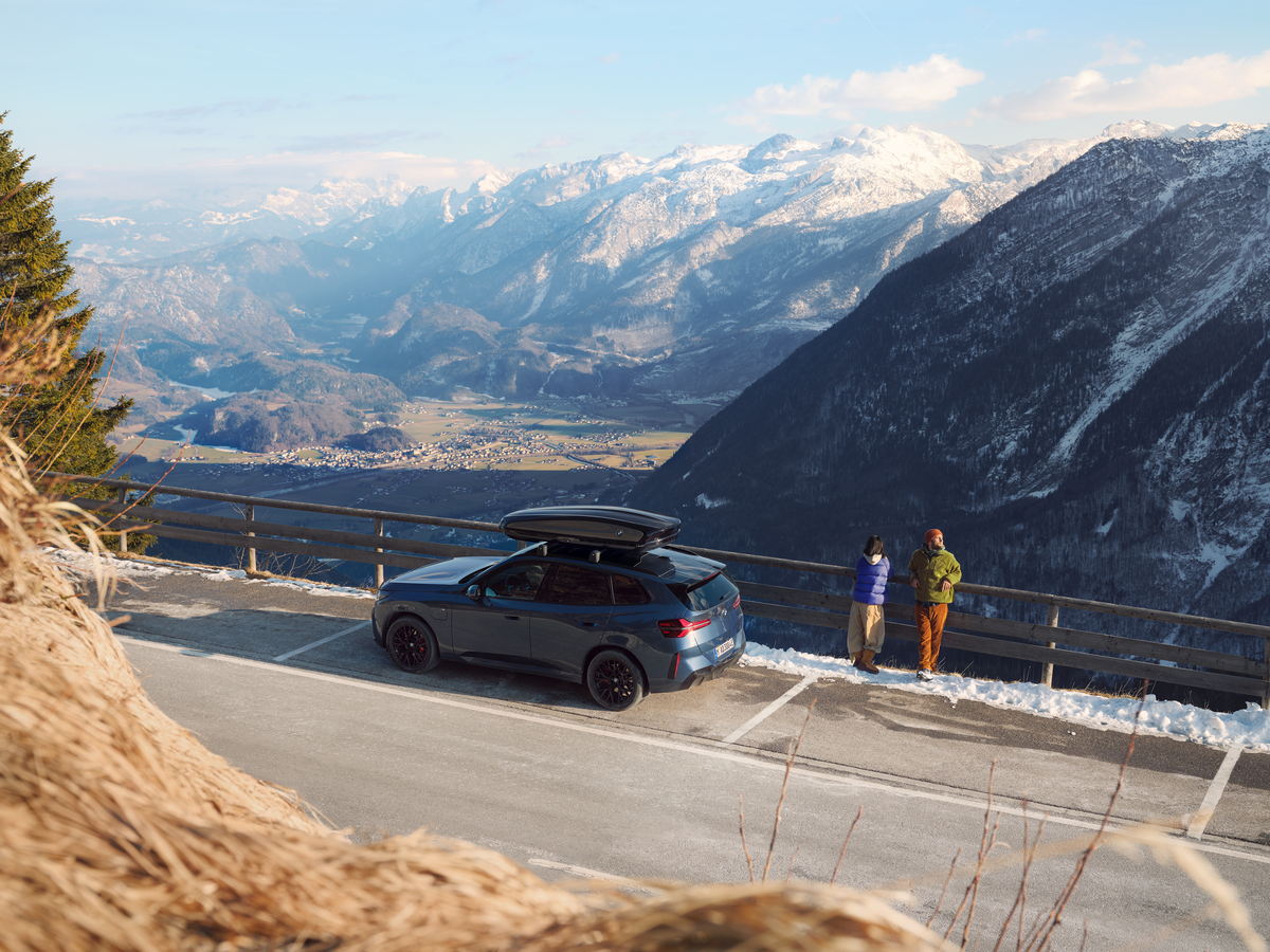 Pärchen mit BMW X3 vor einem winterlichen Bergpanorama