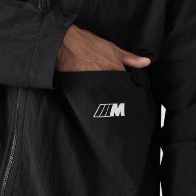 Hand greift in Jackentasche mit M Logo