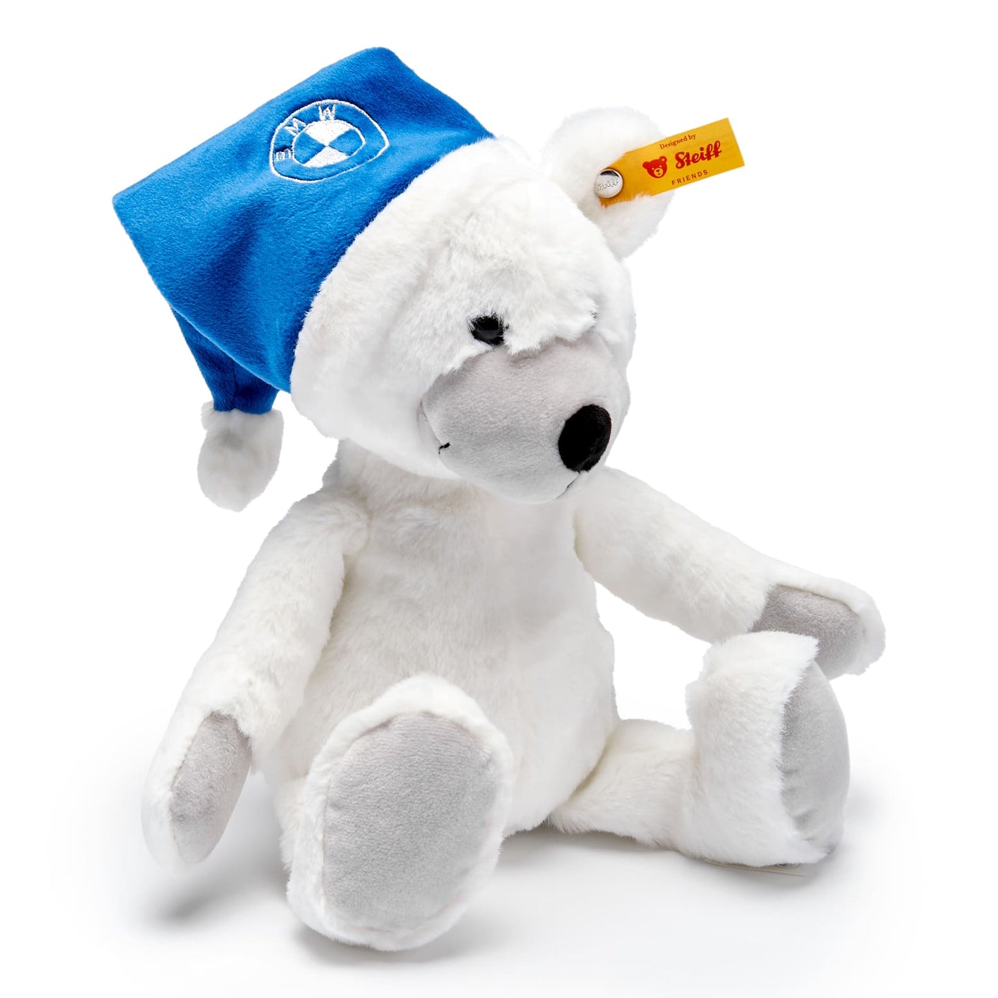 Weißer Steiff Teddybär mit dem markentypischen Knopf im Ohr und blauer Mütze mit BMW Logo bestickt