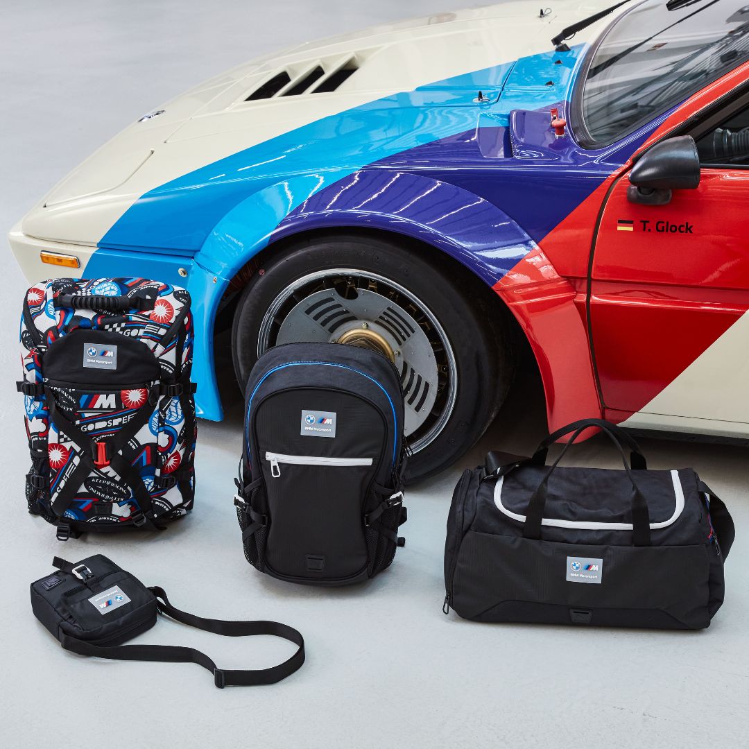 BMW M Performance Taschen und Rücksäcke vor einem Auto