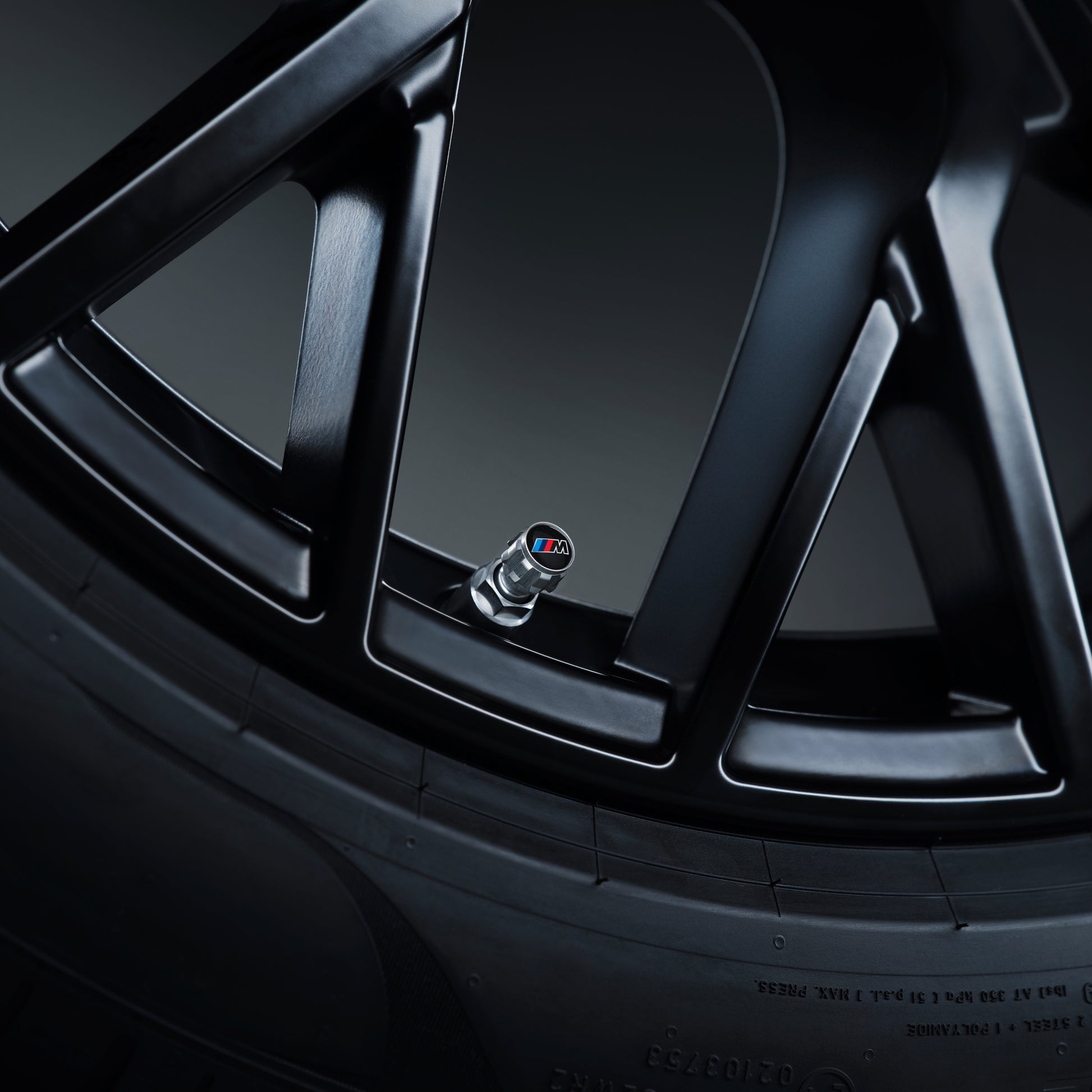 Antrazit-farbene BMW M Ventilkappen an einem Rad im Neue Klasse Design